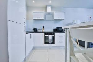 uma cozinha branca com armários e electrodomésticos brancos em StayRight 1-Bed City Nest in Cardiff em Cardiff