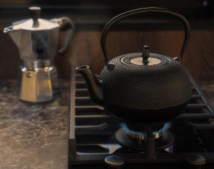- Hervidor de té negro sobre una estufa en Koppla Cabin, en Felbridge
