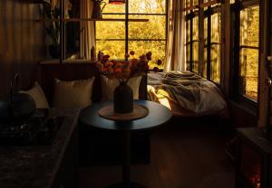un jarrón de flores en una mesa frente a una ventana en Koppla Cabin, en Felbridge