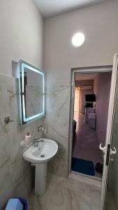 a bathroom with a sink and a mirror at Serene Stay in Vlorë