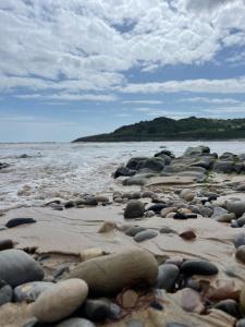 a group of rocks on a beach near the water at ✪ LEISURE/BUSINESS ✪ 1 Bedroom Apt , Free Parking in Swansea