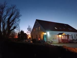 a house with lights on the side of it at night at Ferienwohnung Leuchtturm - b51002 in Oldenswort