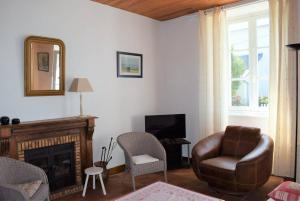 sala de estar con chimenea, silla y espejo en Maison à 100m plage de Tourony avec jardin clos à TREGASTEL - Réf 400, en Trégastel