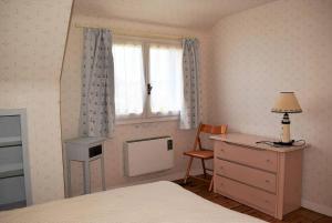 1 dormitorio con cama, escritorio y ventana en Maison à 100m plage de Tourony avec jardin clos à TREGASTEL - Réf 400, en Trégastel
