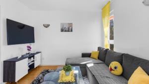 sala de estar con sofá gris y TV en Apartment Sana with Sea View, en Novigrad Istria