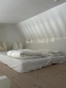 ein weißes Bett mit weißer Bettwäsche und Kissen in der Unterkunft Tversted Strandpark in Bindslev