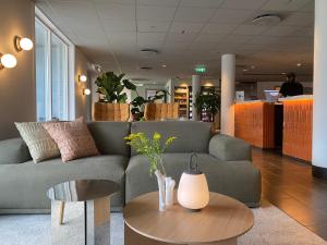 a living room with a couch and a table at Comfort Hotel Park in Trondheim