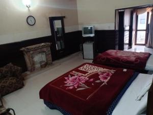 sypialnia z 2 łóżkami i zegarem na ścianie w obiekcie The Royal Family Couples Guest House w mieście Lahaur