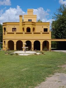 un gran edificio amarillo con una fuente en el patio en El Castillo en Campana