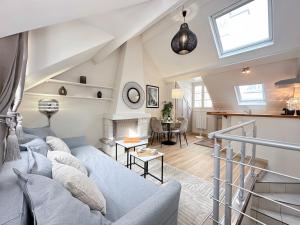 uma sala de estar com um sofá azul e uma mesa em 2066 - Duplex in Saint-Germain Olympic Games 2024 em Paris