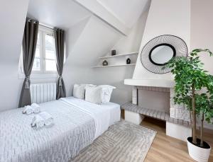 um quarto branco com uma cama e um espelho em 2066 - Duplex in Saint-Germain Olympic Games 2024 em Paris