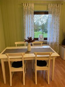 une table à manger avec deux chaises et une fenêtre dans l'établissement Ferienwohnung Naturpunkt, à Isselburg