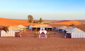a market in the middle of a desert at Aladdin Merzouga Camp in Merzouga