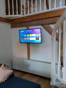TV de pantalla plana en la pared de la sala de estar. en Bezaubernde Ferienwohnung in der alten Schmiede en Rheinsberg