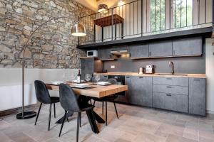 uma cozinha com uma mesa de madeira e cadeiras pretas em Il Poggetto em Rignano sullʼArno
