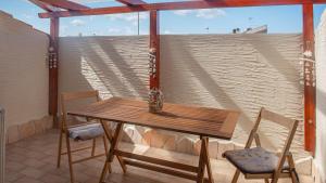 un tavolo in legno e 2 sedie sul balcone di Casa Vacanze Ammentos a Olmedo