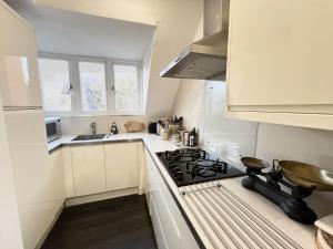 a white kitchen with a stove and a sink at Peaceful flat in The Park in Nottingham