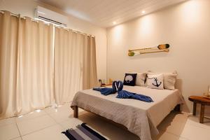 a bedroom with a bed with blue towels on it at Flats Japaratinga - a 200m da praia com varanda in Japaratinga