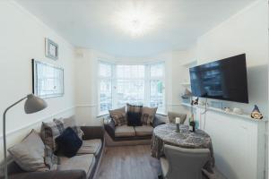 a living room with a couch and a tv at One bedroom flat in Harrow. in Harrow