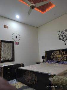 sypialnia z łóżkiem i wentylatorem sufitowym w obiekcie Muslim friendly guest house w mieście Sijalkot