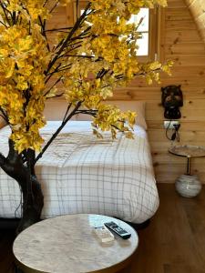 a bedroom with a bed and a tree next to a table at Camping Ripolles in Ripoll