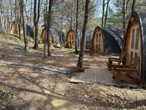 un grupo de tiendas de madera en el bosque en Camping Ripolles, en Ripoll