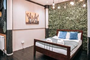 een slaapkamer met een bed en een groene muur bij Party flat for groups, garden, parking + central in Bournemouth