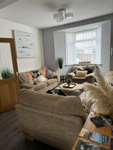 a living room with two couches and a table at Modern, spacious and Central Location in Aberdare