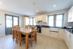 a kitchen with a wooden table and chairs at Escape Ordinary at Lough Erne GV - No.32 in Enniskillen