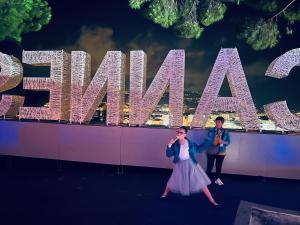 due persone in piedi davanti al cartello di Miami di Naomi cannes a Cannes