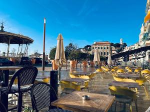 ein Café im Freien mit Tischen, Stühlen und Sonnenschirmen in der Unterkunft Naomi cannes in Cannes
