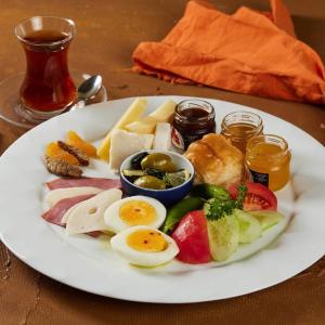 a plate of food with eggs and vegetables on a table at Green Star Pera Hotel in Istanbul