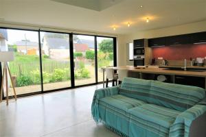 ein Wohnzimmer mit einem Sofa und einer Küche in der Unterkunft Maison de plain-pied avec WIFI, jardin, terrasse à PLEUMEUR - BODOU REF-457 in Pleumeur-Bodou