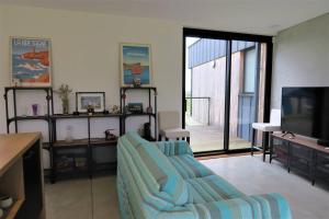 a living room with a couch and a tv at Maison de plain-pied avec WIFI, jardin, terrasse à PLEUMEUR - BODOU REF-457 in Pleumeur-Bodou