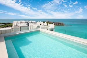 a swimming pool with a view of the ocean at The Residences at The St. Regis Bermuda in Saint George