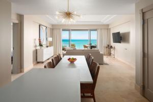 Saint George的住宿－The Residences at The St. Regis Bermuda，用餐室以及带白色桌椅的起居室。