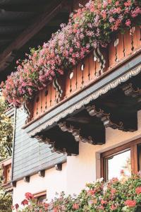 a balcony filled with flowers on the side of a building at B & B Feistererhof in Ramsau am Dachstein