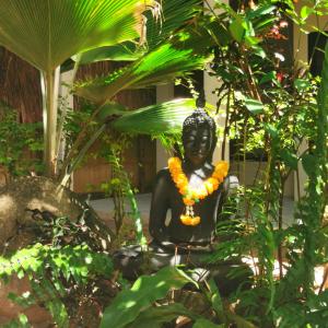 a statue of a woman sitting in a garden at Jade cottages in Koh Samui 