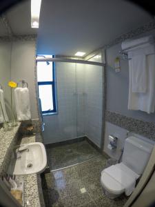 y baño con aseo, lavabo y ducha. en Royal Boutique Savassi Hotel, en Belo Horizonte