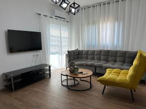 ein Wohnzimmer mit einem Sofa und einem TV in der Unterkunft סוויטה בזכרון in Zichron Ja’akow
