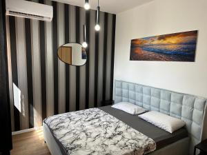 ein Schlafzimmer mit einem Bett und einem Wandgemälde in der Unterkunft סוויטה בזכרון in Zichron Ja’akow