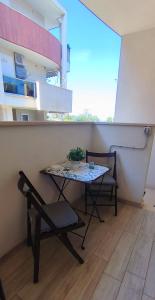 una mesa y una silla en una habitación con ventana en Alba b&b, en Polignano a Mare