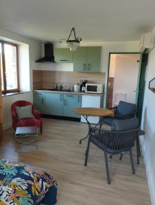 a kitchen with a table and chairs in a room at La Verdine in Vérin