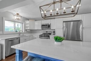 a kitchen with white cabinets and a white counter top at Waterfront Sun-Drenched Hermit Lake Retreat! in Sanbornton