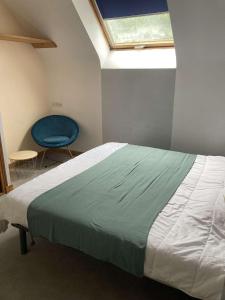 1 dormitorio con 1 cama y 1 silla azul en Villa de plain-pied avec WIFI, piscine privée sous abris haut à PLEUMEUR-BODOU - Ref 461 en Pleumeur-Bodou
