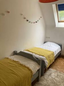 2 camas en una habitación con sábanas amarillas en Villa de plain-pied avec WIFI, piscine privée sous abris haut à PLEUMEUR-BODOU - Ref 461 en Pleumeur-Bodou