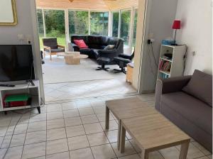 sala de estar con sofá y TV en Villa de plain-pied avec WIFI, piscine privée sous abris haut à PLEUMEUR-BODOU - Ref 461 en Pleumeur-Bodou
