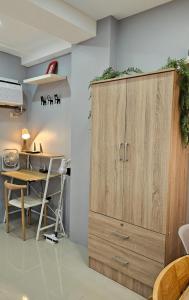 a large wooden cabinet in a kitchen with a table at THE FIKA ROOM near MNL Airport - Scandi Studio Unit with Fast Wi-Fi & Netflix - Read Full Property Desc before booking in Manila