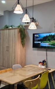 uma sala de jantar com uma mesa e uma televisão na parede em THE FIKA ROOM near MNL Airport - Scandi Studio Unit with Fast Wi-Fi & Netflix - Read Full Property Desc before booking em Manila