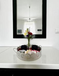 a plate with a vase of flowers and a mirror at Downtown Delight: Chic Oasis in Zagreb